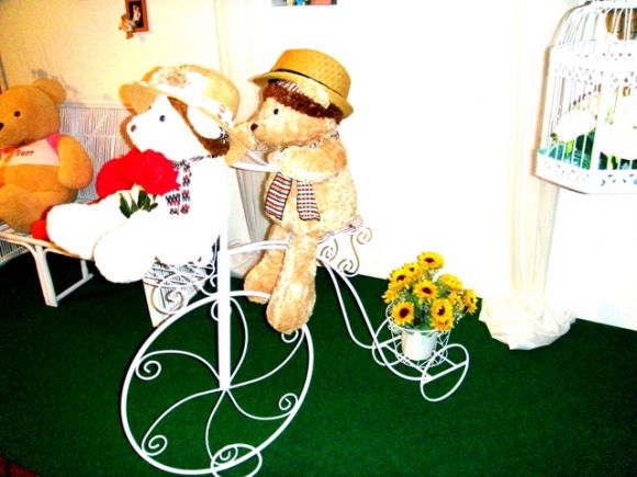 จักรยานสีขาว ประดับตะกร้าดอกไม้และตุ๊กตาหมี