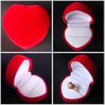 กล่องใส่แหวนเป็นกล่องกำมะหยี่สีแดงรูปหัวใจ พื้นด้านในเป็นกำมะหยี่สีขาว